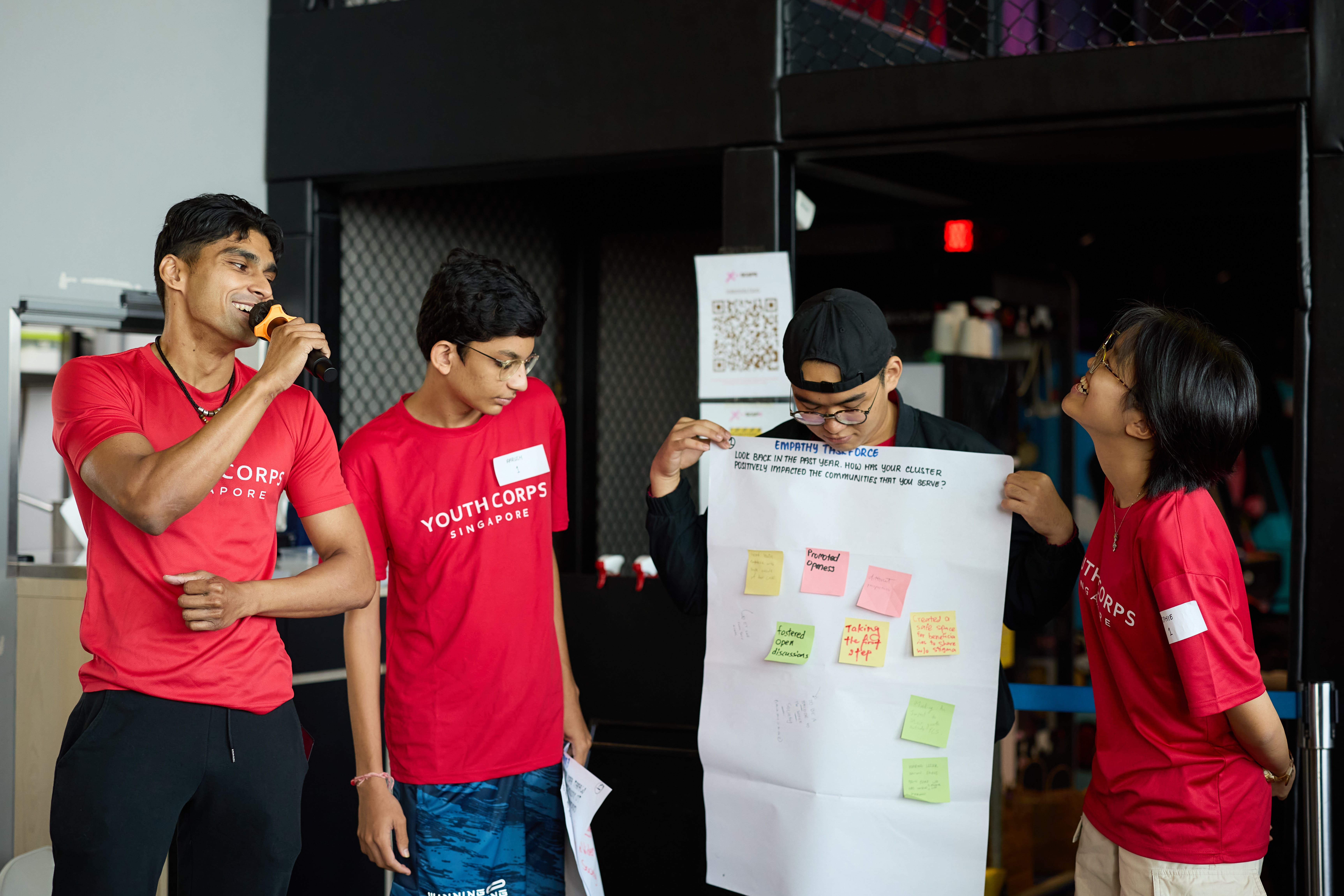 Youth Corps volunteer holding a mic presenting his group's work.